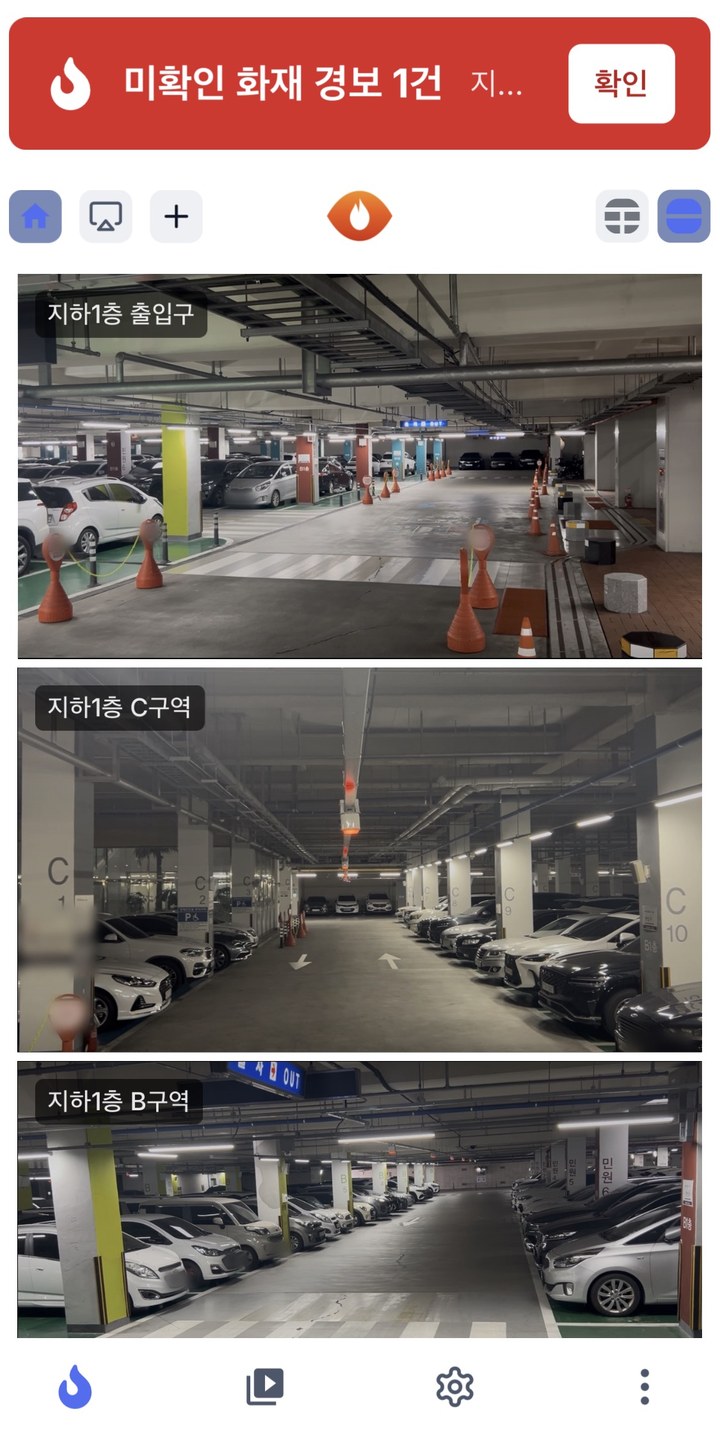 휴대폰 화면 — 상단에 미확인 화재 경보 배너와 확인 버튼이 있고 아래로 카메라 화면이 이어짐